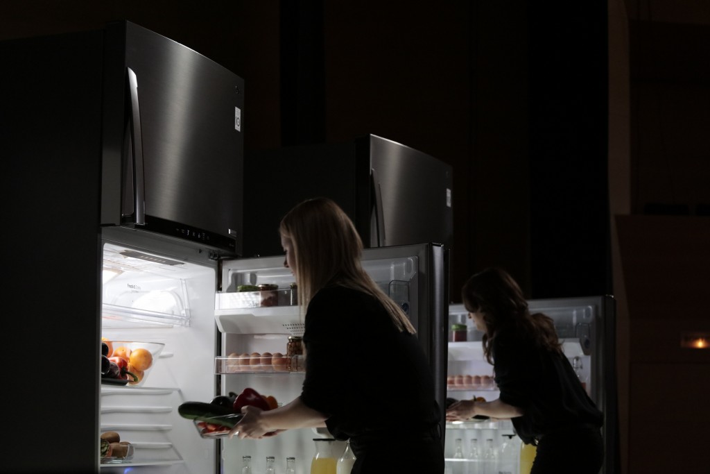 Two female musicians take food from LG’s advanced refrigerators.