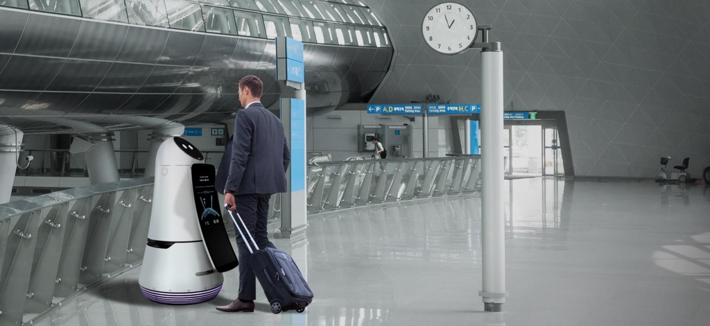 A man checking in at the airport with the help of the LG Airport Guide Robot.