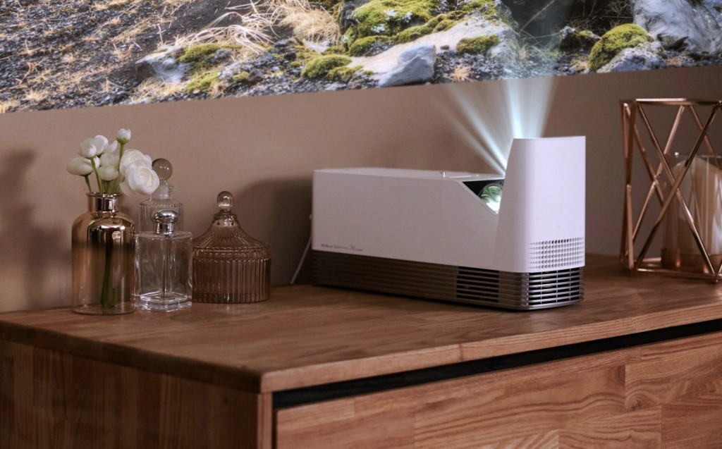 The LG ProBeam Projector model HF85J placed on top of living room furniture.