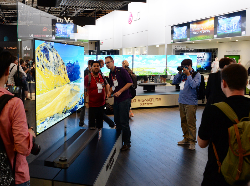 Visitors to LG IFA booth examining the minimal depth of LG SIGNATURE OLED TV W