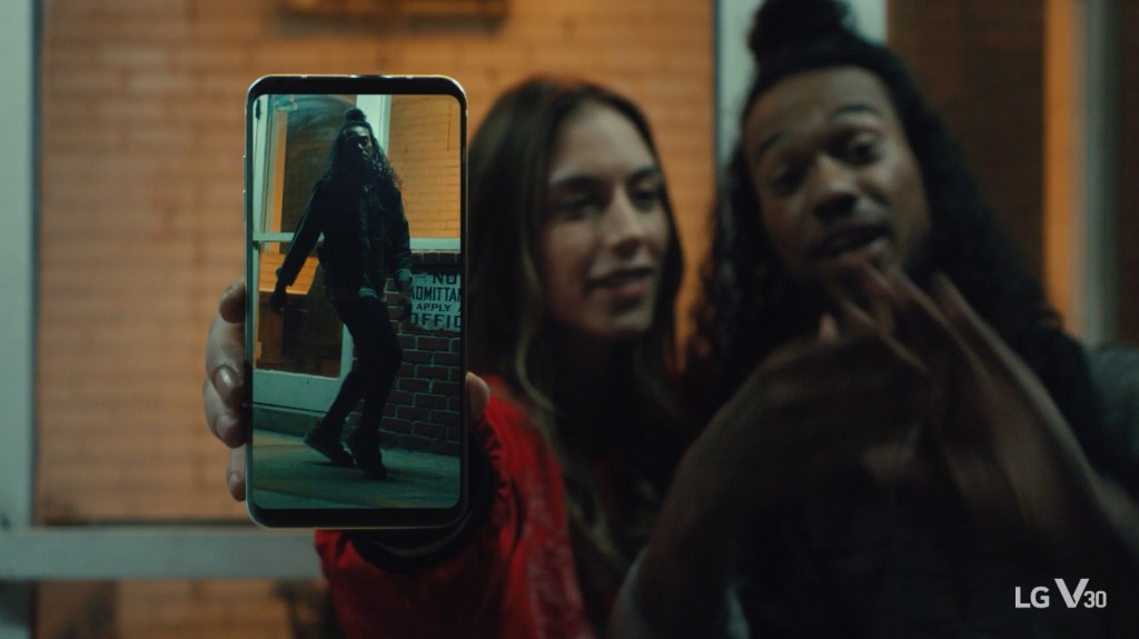 An image from the video clip shows Caroline Blaike standing next to Shaheem Sanchez while she holds LG V30 out towards the screen
