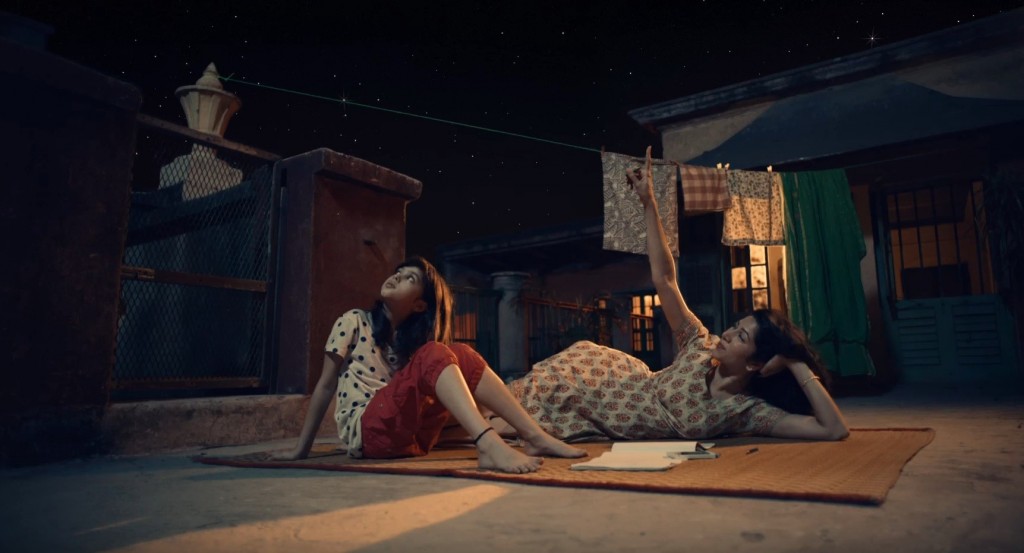 A screenshot of LG India’s “Astronaut” video, there are two women looking up towards the night sky