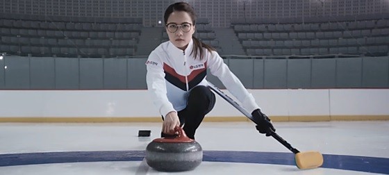 Skip Kim Eun-jung launches a stone with a broom in her left hand.