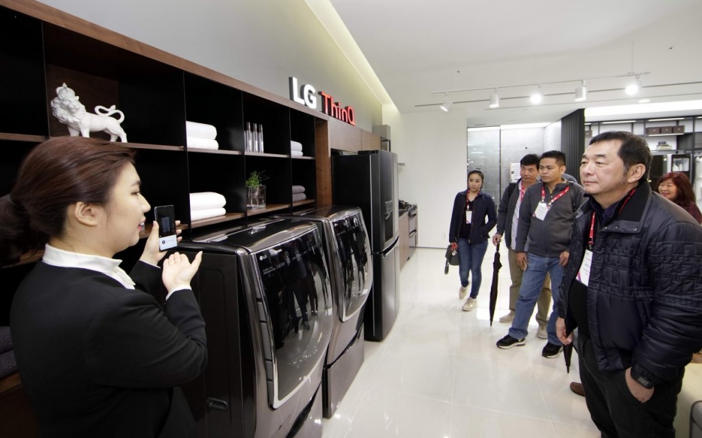 A female presenter introduces LG ThinQ AI features that can control LG’s home appliances by using LG’s smartphones.