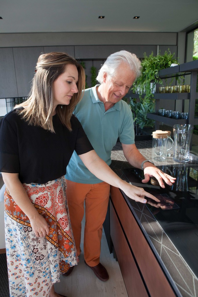 Two attendees touch the furniture at the LG Eco-City Garden booth.