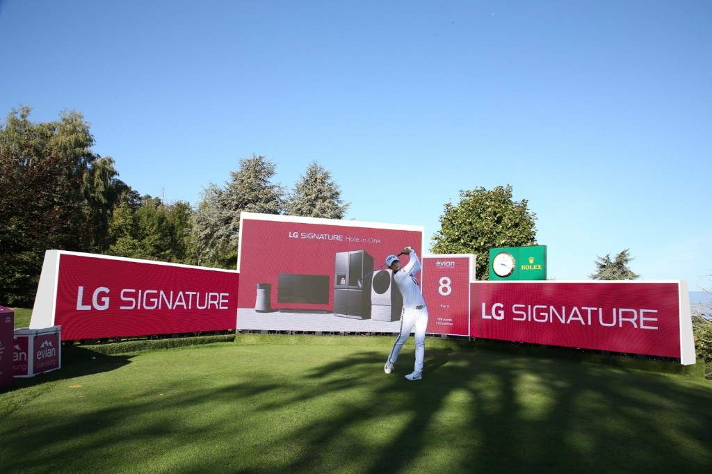 A golfer hits a ball right in front of the LG Signature signage.