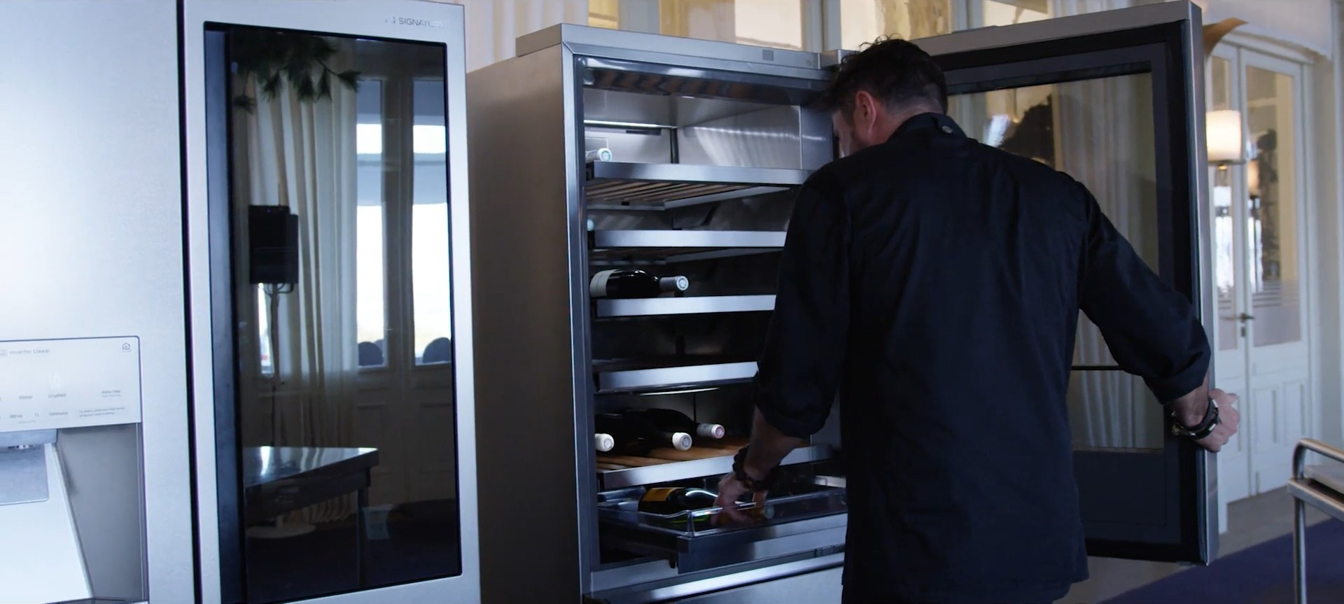 German star chef Christopher Crell takes out a bottle of wine from the LG SIGNATURE wine cellar.