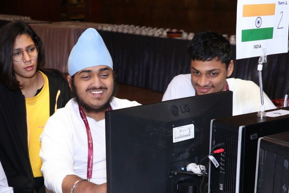 Members of the India team smile while looking at the LG monitor