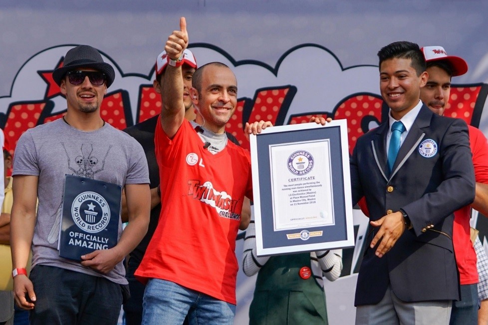 A representative from Guinness World Records hands over the world record certificate to LG’s event manager.