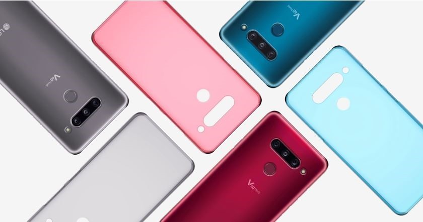 Three LG V40 ThinQs face down on a table with back cases positioned in a brick pattern.