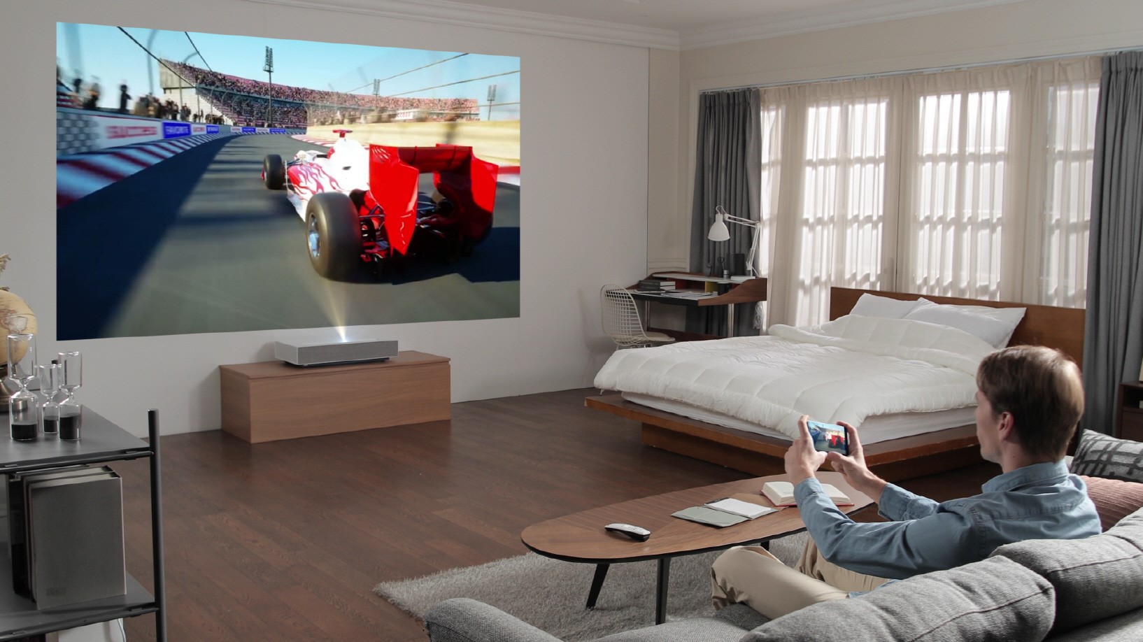 A man playing a video game with the LG CineBeam Laser 4K projector model HU85L.