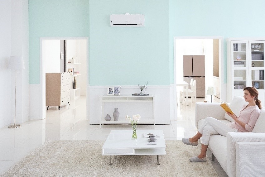 A woman on the sofa enjoys the enhanced indoor air quality thanks to LG’s DUALCOOL air conditioner, which detects and eliminates tiny airborne particles such as PM1.0.