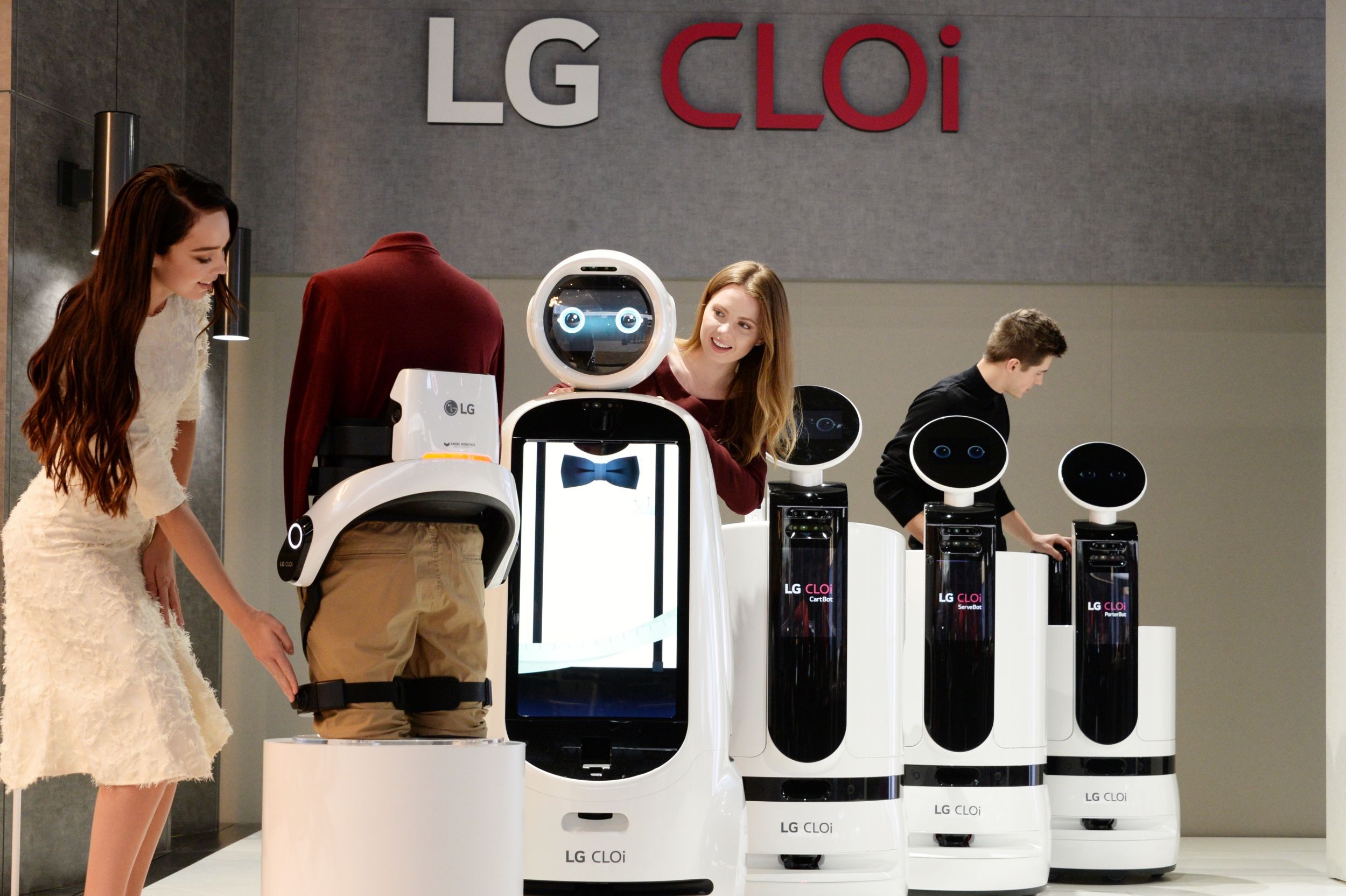 Female and male models look around the LG’s CLOi commercial robot samples.