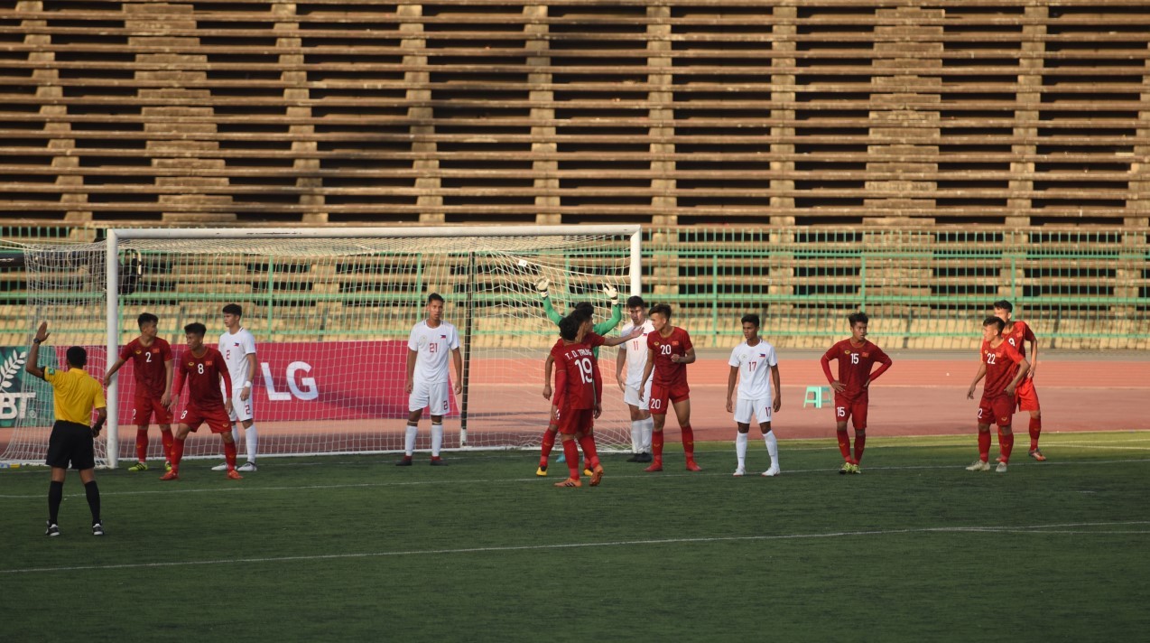 Players wait for a corner-kick inside the penalty box and there is LG’s pitch-side advertisement board behind the goal.