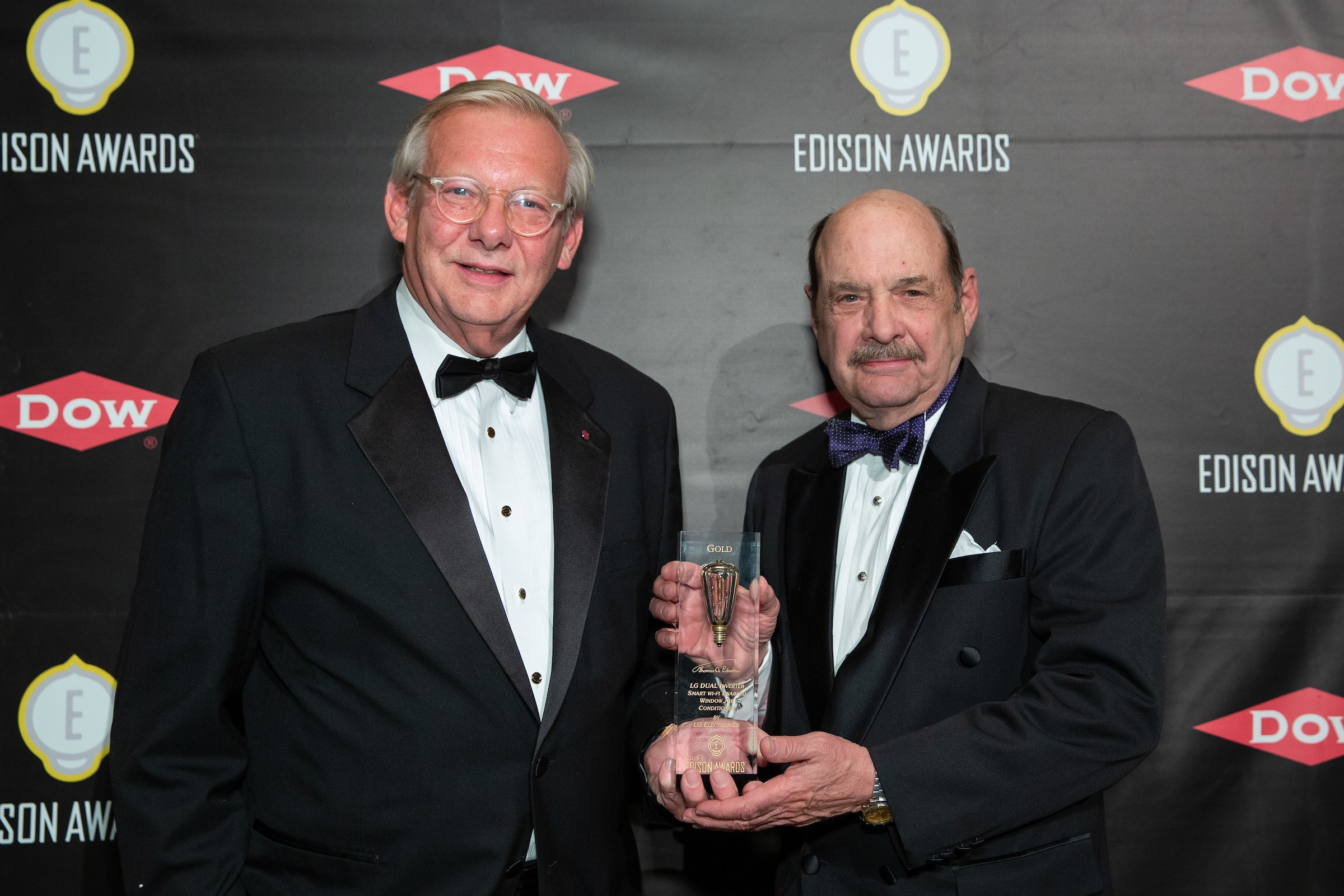 John Taylor, Senior Vice President of Public Affairs for LG USA receives the trophy from the representative of 2019 Gold Edison Award.