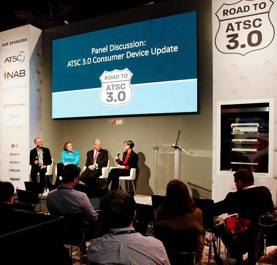 LG’s large display hangs against the wall over the podium for a panel discussion during the Road to ATSC 3.0 exhibit event.