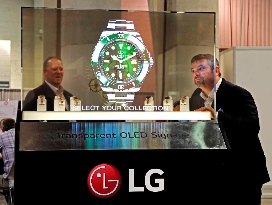 Two NAB Show attendees behold the LG Transparent OLED display which shows a piece of watch.