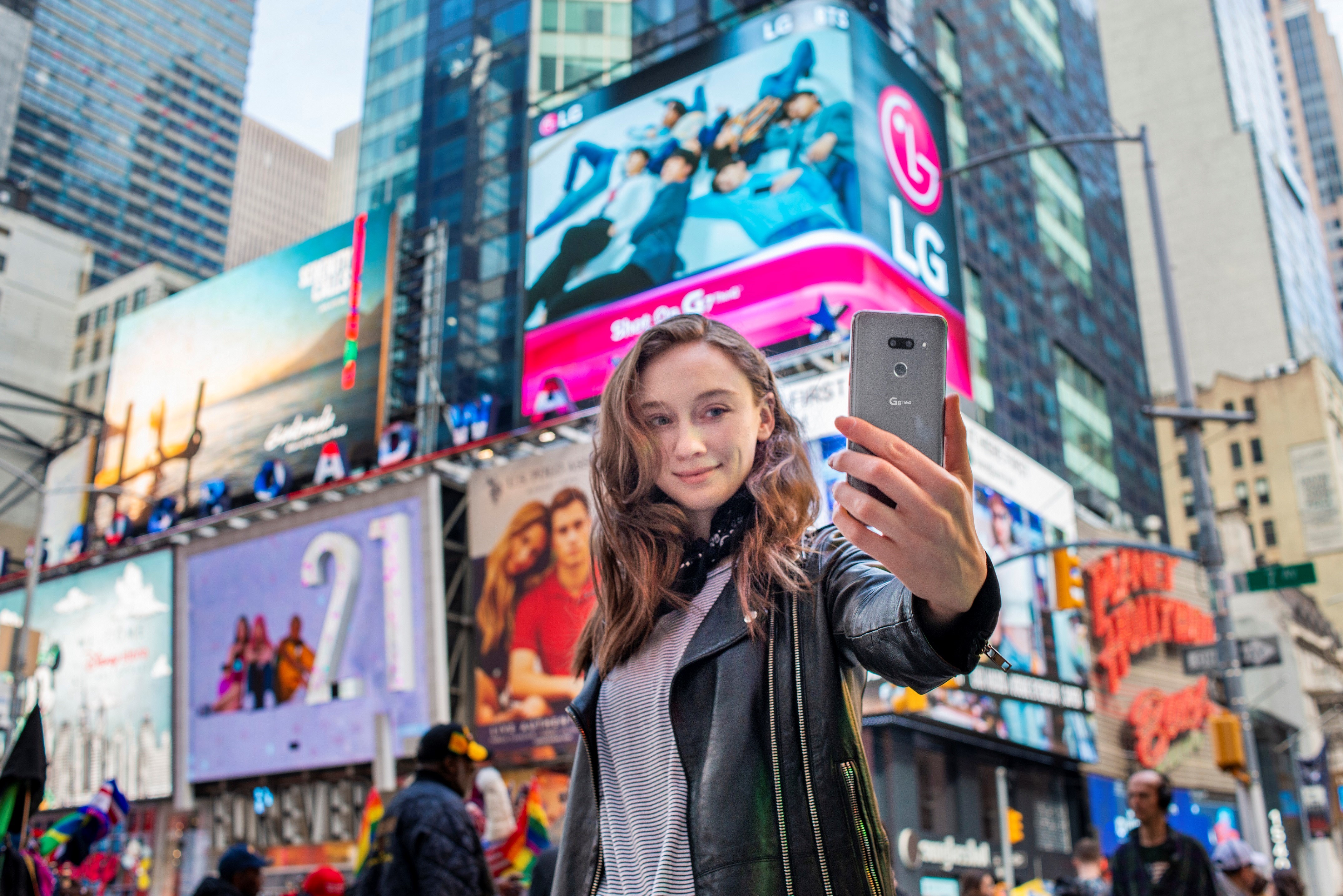 A woman holds the LG G8 ThinQ out to take a selfie in Times Square, New York.