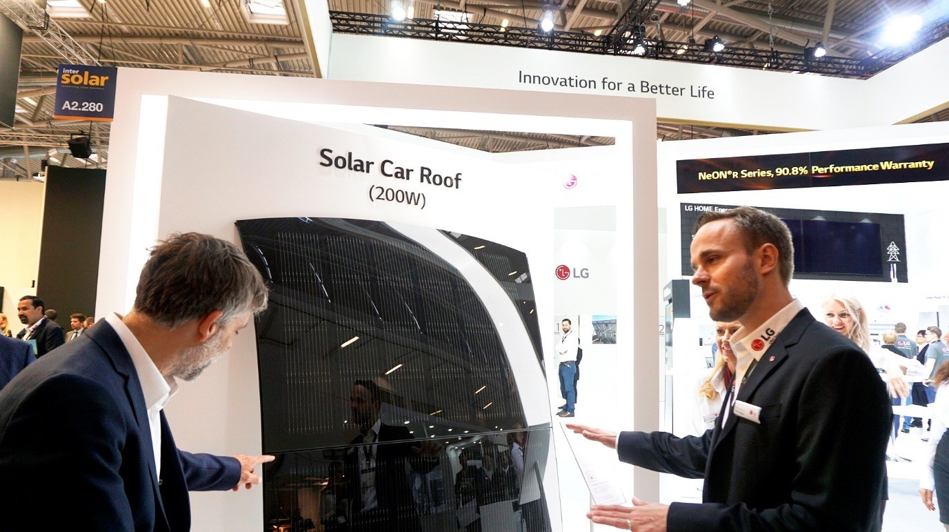 A male attendant explains the main features of LG Solar Car Roof to a visitor at its Intersolar Europe booth.