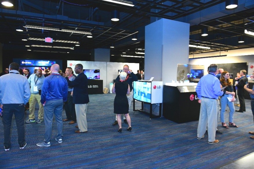 A looking inside the 2019 LG TechTour’s venue, with attendees browsing and discussing LG’s B2B products