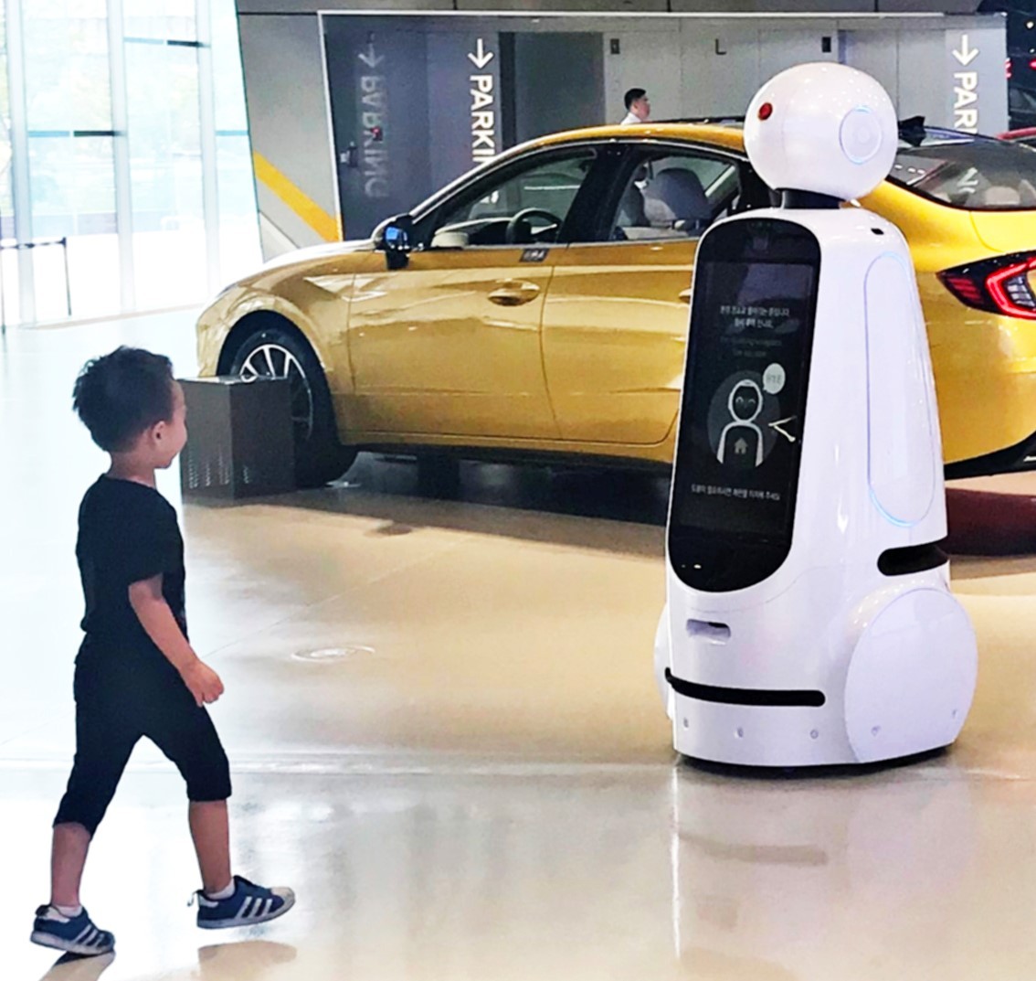 A little boy walks towards LG CLOi GuideBot at the Hyundai Motor Studio Goyang.