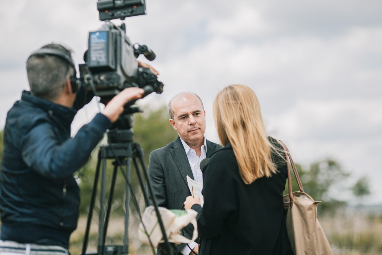 A project representative gives an interview with a local broadcast media.