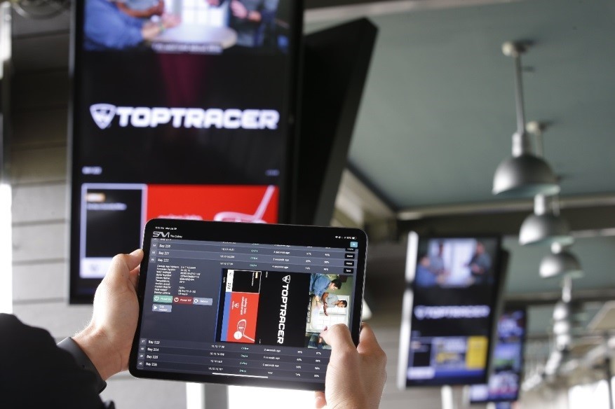 A man holds up a SAVI Canvas tablet to remotely manage the information displayed on LG’s commercial digital signage solutions.