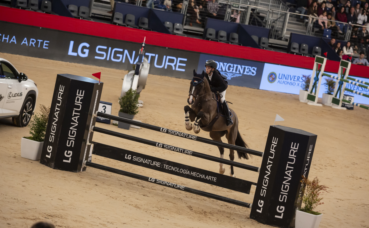 A rider and her horse leap over a tall hurdle at an equestrian competition while the jump displays the LG SIGNATURE logo to highlight the brand as the main sponsor.