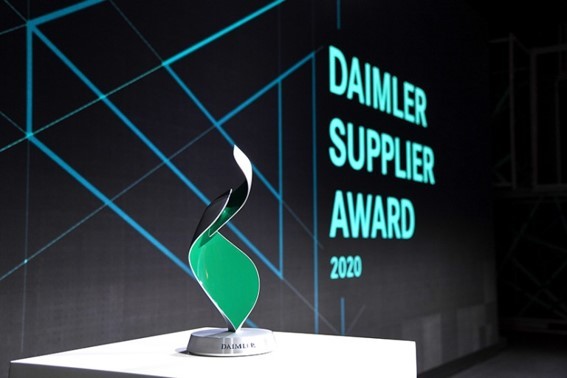 A close-up of the trophy, with the Daimler Supplier Award 2020 Logo displayed behind