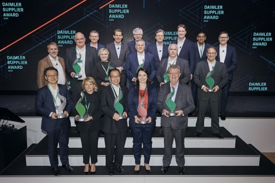 Winners of a Daimler Supplier Award pose with their trophies on the main stage