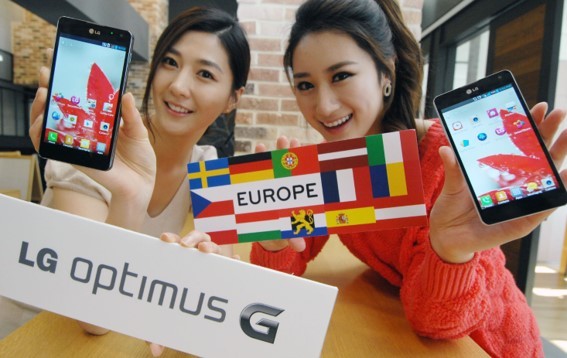 Two women show off LG Optimus G while holding up many European flags