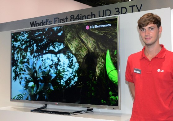 A male attendant stands next to the world's first LG 84-inch 4K 3D TV which is placed on a display stand.