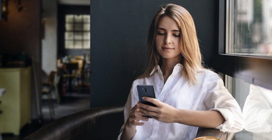 A woman uses her LG smartphone in the home