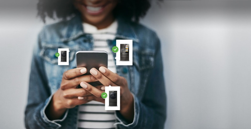 A girl smiles as she monitors her home appliances from a smartphone