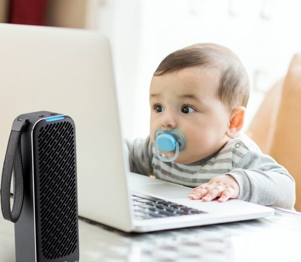 An adorable baby stares at a laptop monitor as the LG PuriCare Mini Air Purifier works in the foreground.
