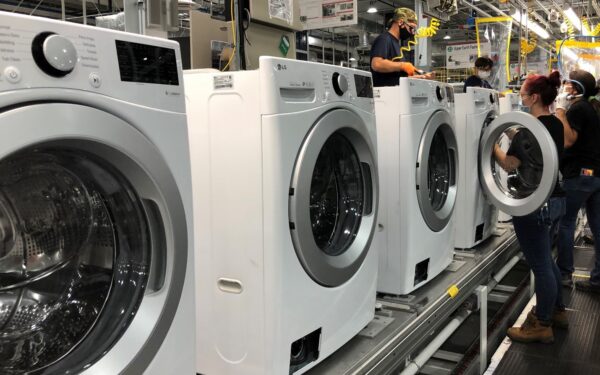 A team of US factory workers assembling LG washing machines moving down the production line