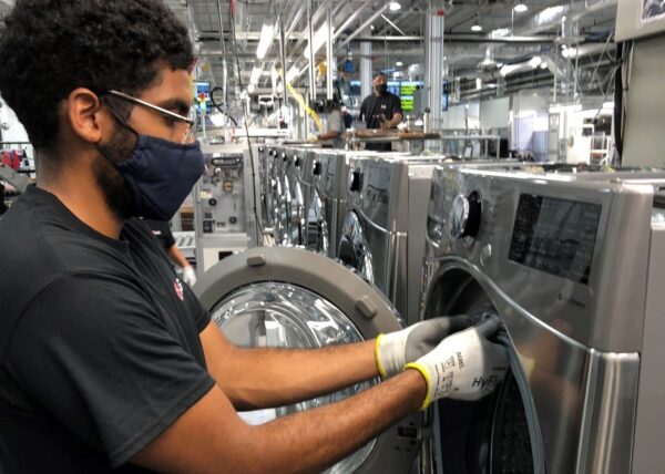 A closer look at one US factory worker fitting a part to the LG washer’s door