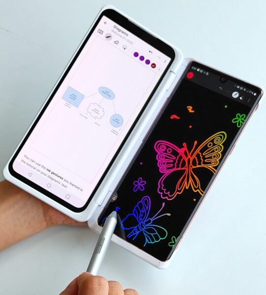 A person using LG VELVET and Dual Screen to edit a diagram on one screen while doodling colorful butterflies on the second screen