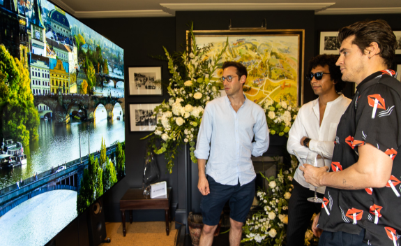 Three male attendees of SIGNATURE’s Goodwood event take a closer look at the clear, vivid imagery provided by the LG SIGNATURE 77-inch OLED TV