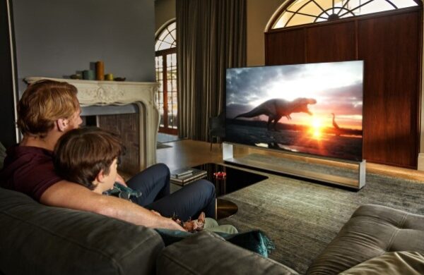 A father and son watch a movie on LG’s OLED TV which provides a true cinematic experience
