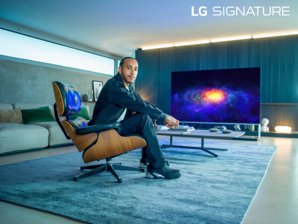 World Champion Lewis Hamilton, who has been appointed as a global ambassador for LG SIGNATURE, sitting in front of LG OLED TV as he poses for the camera