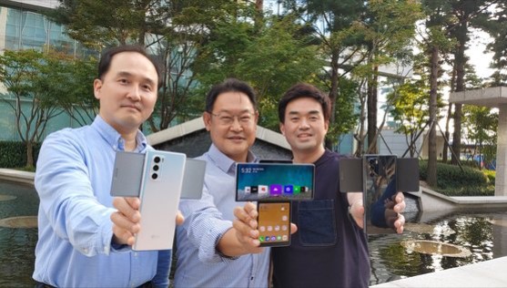 Three members of the LG MC team who worked closely on the LG WING development project hold up the device in Swivel mode while showcasing its different colors