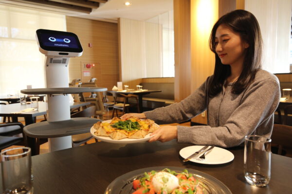 A person being served by LG ChefBot at a restaurant