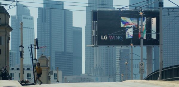 A billboard advertisement displaying the front and rear view of LG WING in Michael Bay’s upcoming film, Songbird 
