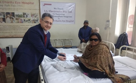 A man hands a patient a document at Dr. Shroff’s Charity Eye Hospital