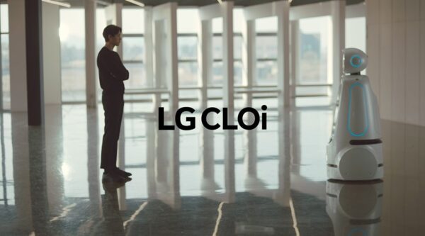 The LG CLOi robot designed to assist humans in public spaces standing face-to-face with a man in a building lobby.