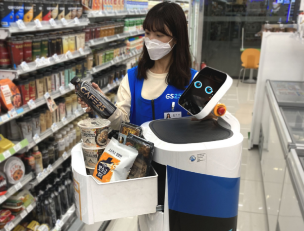 LG CLOi ServeBot working at a convenience store at LG Sciencepark as an employee fills it up with snacks for delivery. 