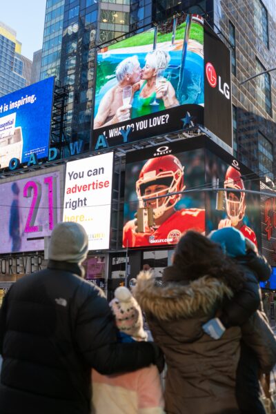 A family pause while walking through Times Square to watch the documentary on LG's giant commercial display.