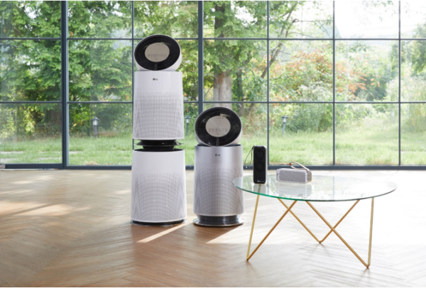 The four LG Purifier models ranging from the residential to handy portable model displayed in an open room with a large window overlooking the garden.