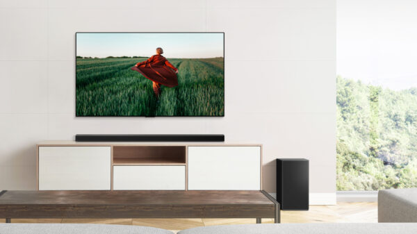 LG Soundbar sitting on a wooden cabinet below the wall-mounted LG TV to complement the TV's sound while blending effortlessly into the earthy room décor